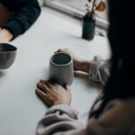 Foto av to personer som samtlaer over en kopp te ved Priscilla Du Preez 🇨🇦 fra Unsplash