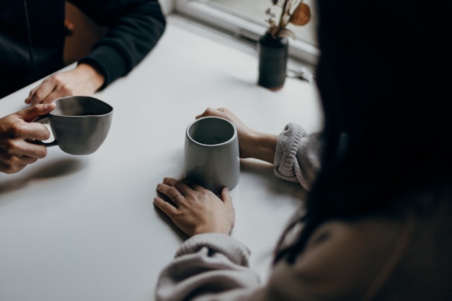 Foto av to personer som samtlaer over en kopp te ved Priscilla Du Preez 🇨🇦 fra Unsplash